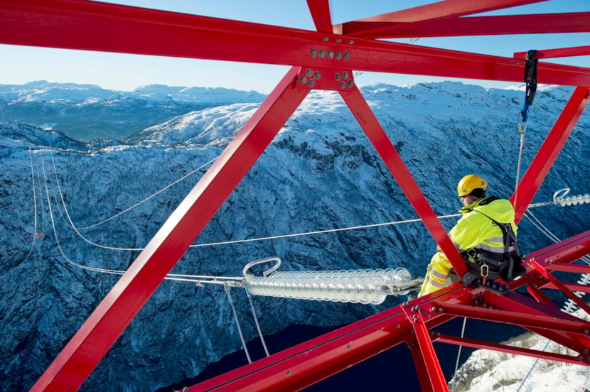 Person høyt oppe i mast under bygging av Ofoten-Balsfjord
