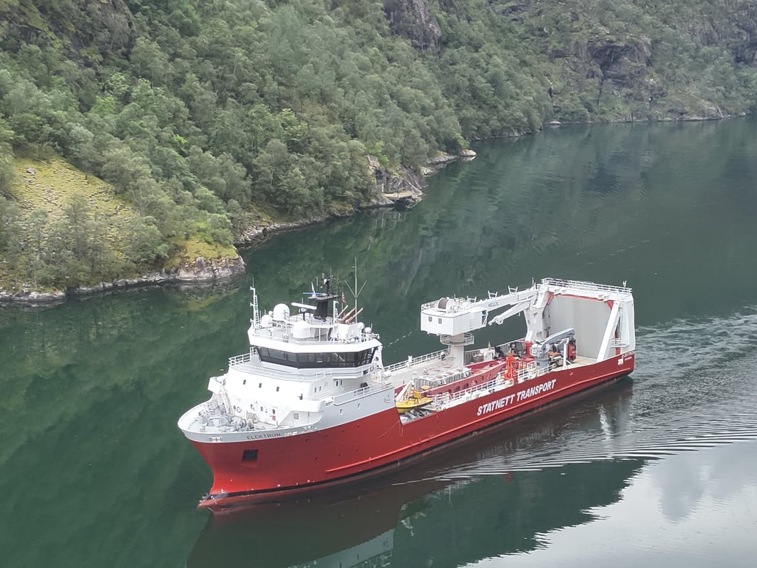 Bilde av et stort skip og fjord i bakgrunnen