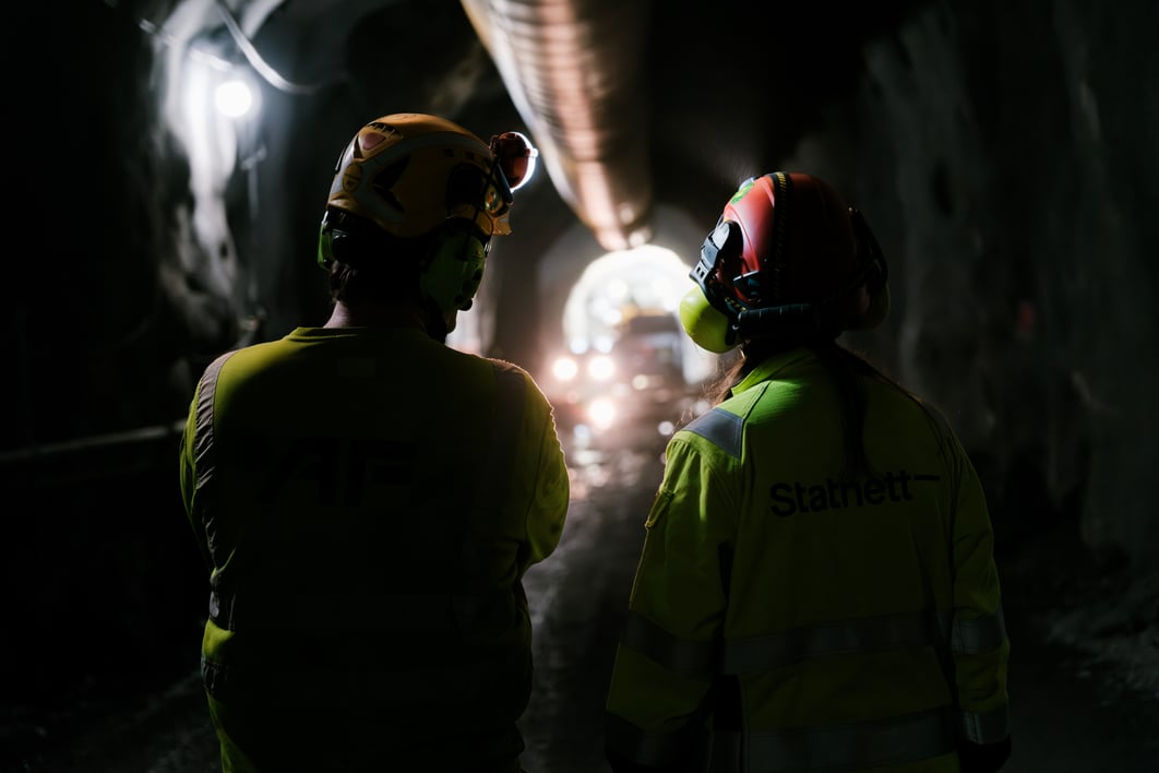 Bilde av to personer med ryggen til i en tunnel