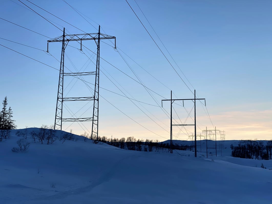 Kraftledninger krysser et snødekt fjellandskap på Korgfjellet