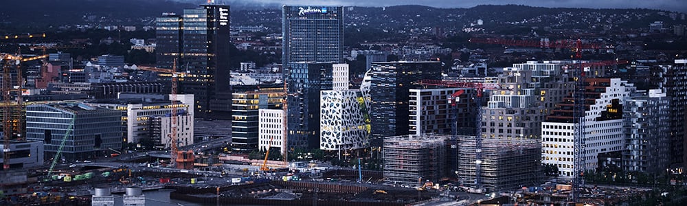 Oslo by med store lysende bygninger om kvelden