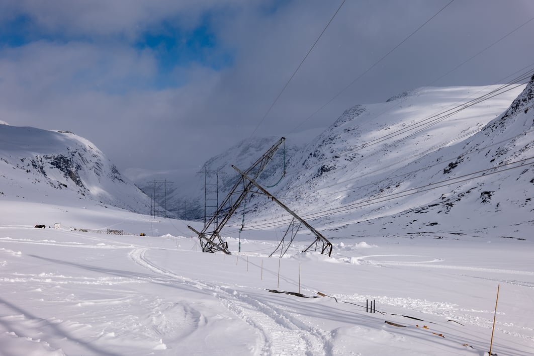 Bilde av en ødelagt mast som er skeiv i snøen