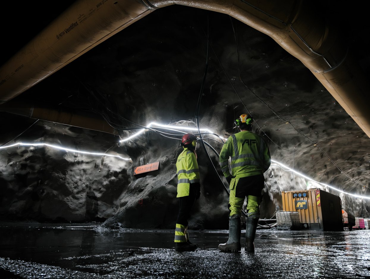 Bilde av to med ryggen til i vernetøy i en tunnel