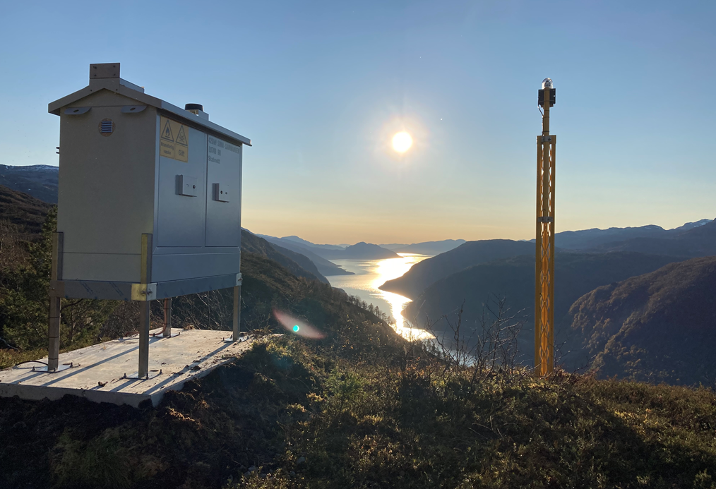 Statnett er i gang med å installere hinderlys over hele landet. Bildet er tatt ved fjordspennet over Granvinsfjorden og viser strømforsynings- og kommunikasjonsskap til venstre og selve hinderlyset på toppen av den gule masten. Foto: Statnett/Tormod Aarekol 
