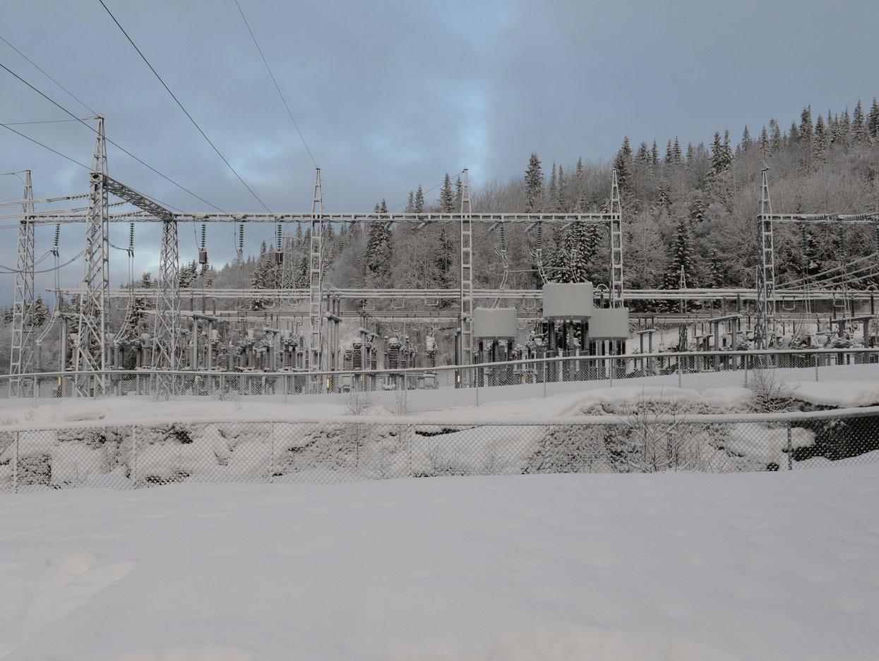 Marka transformatorstasjon i et snødekt landskap omgitt av skog