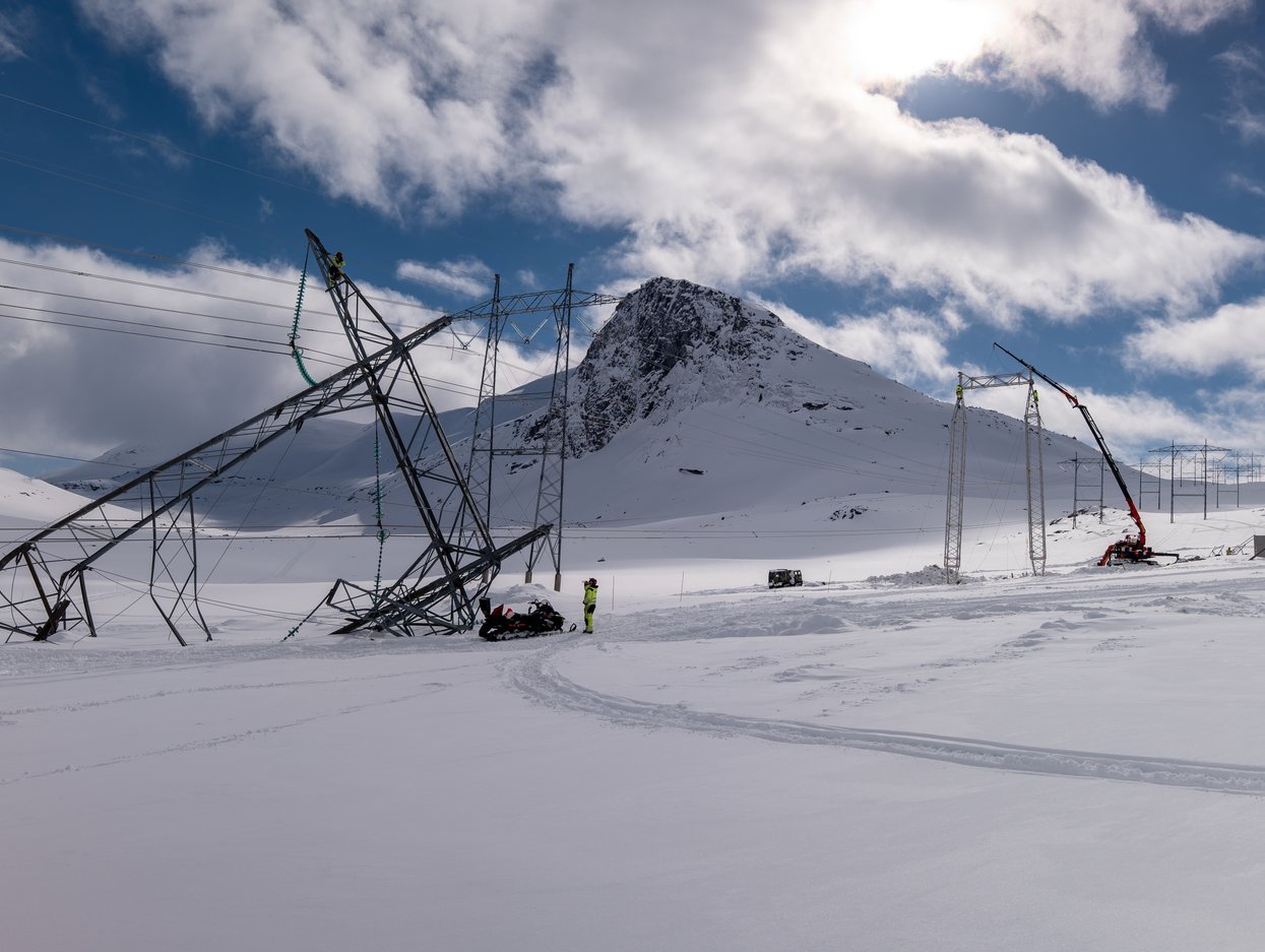 Bilde av snø og høyspentmast som er ødelagt.