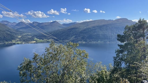 420kv-ledning i spenn over fjord på en vakker sommerdag.