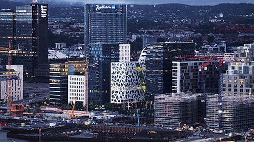 Oslo by med store lysende byggninger om kvelden 