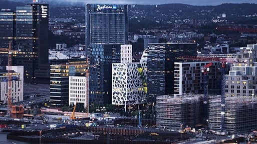 Oslo by med store lysende byggninger om kvelden 