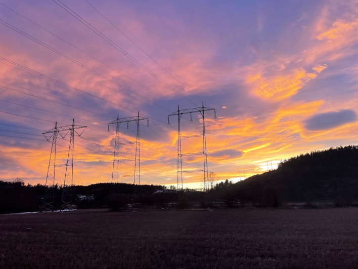 Strømmaster i solnedgang