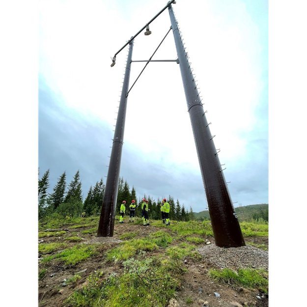 Stor svart mast med ansatte i vernetøy under masten
