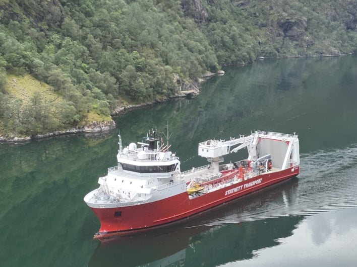 Bilde av et stort skip og fjord i bakgrunnen