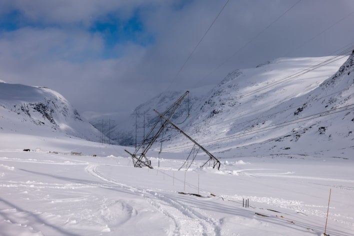 Bilde av en ødelagt mast som er skeiv i snøen