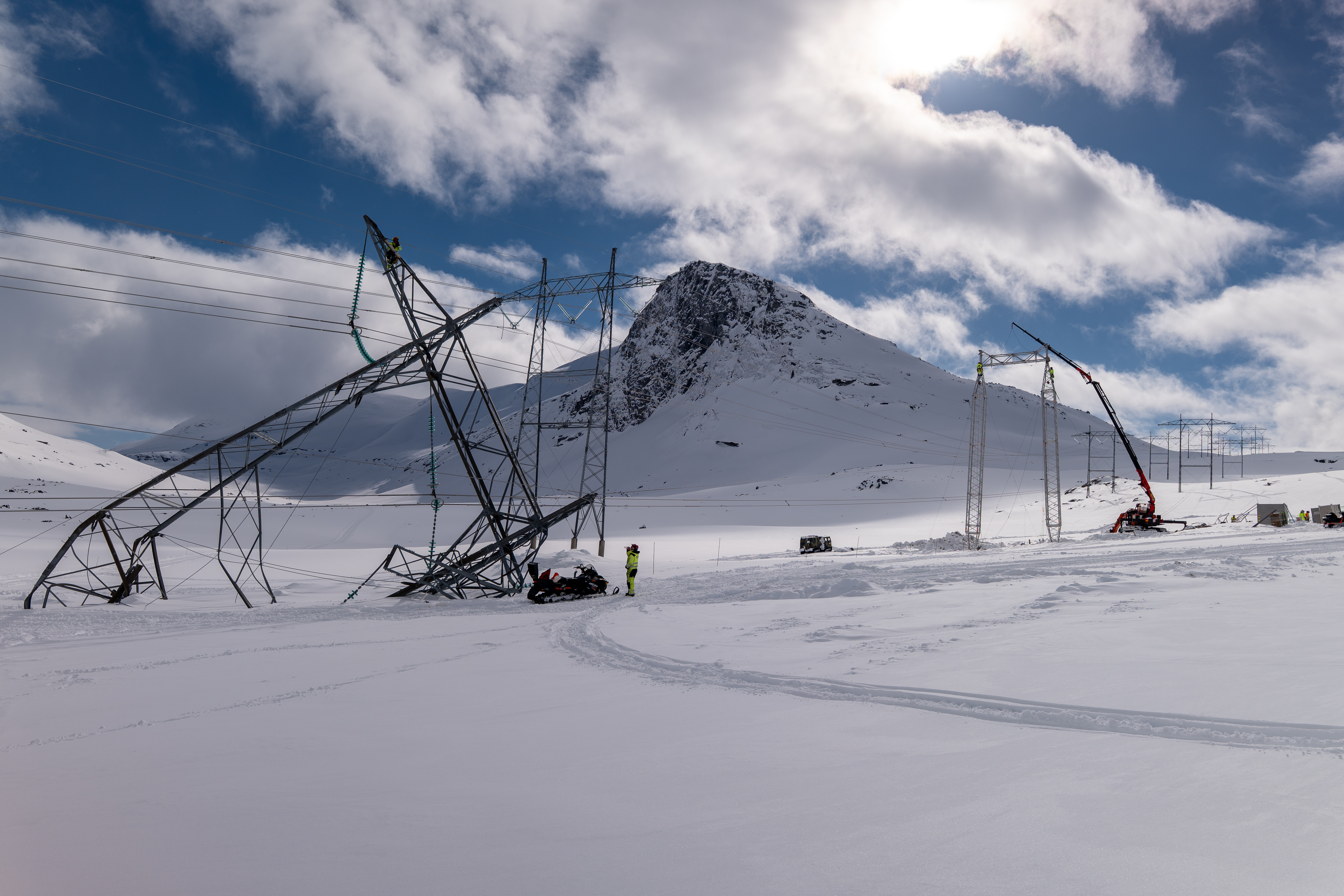 Bilde av snø og høyspentmast som er ødelagt.